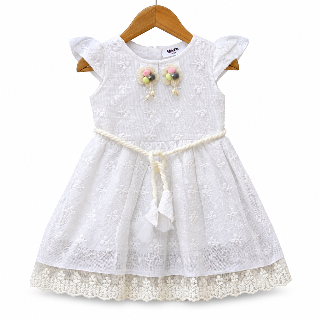Delicate lace embroidery and whimsical pom-pom accents