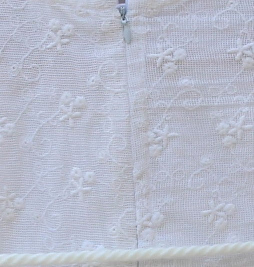 Delicate lace embroidery and whimsical pom-pom accents