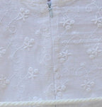 Delicate lace embroidery and whimsical pom-pom accents